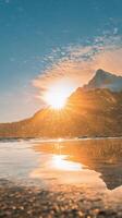 Majestic mountain peak reflects in calm lake at sunrise with vibrant colors photo