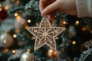 Handmade wooden snowflake ornament hanging on a Christmas tree decorated with lights photo