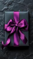 Elegant black gift box with purple ribbon ready for a special occasion photo
