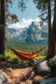 Relaxing hammock between trees overlooking a scenic mountain landscape on a sunny day photo