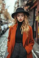 Young woman in urban setting with hat and warm attire during a sunny day photo