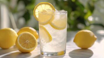 Refreshing lemon beverage on a sunny kitchen counter with bright yellow tiles photo