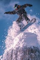 Snowboarder performs a jump in winter wonderland under clear blue sky photo