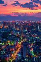 Vibrant city skyline illuminated under colorful sunset with mountains in the background photo