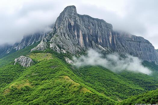 A mountain with clouds and green vegetation photo