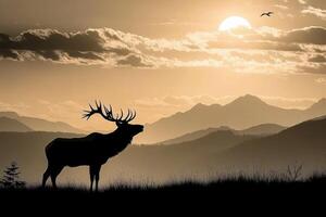 A silhouette of a deer standing in front of mountains photo
