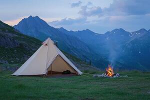 A tent with a fire pit and mountains in the background photo