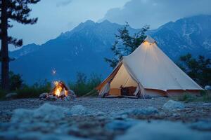 A tent with a fire and mountains in the background photo