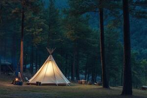 A teepee is lit up in the woods at night photo