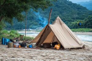 A tent set up on the beach with a river in the background photo