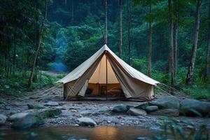 A tent is set up in the woods near a stream photo