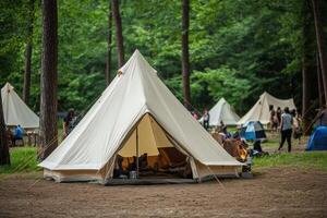 A tent in the woods with people around it photo
