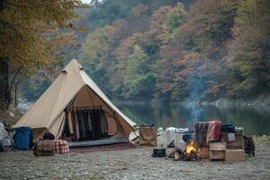 A tent and a fire pit near a river photo