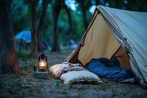 A tent and a lamp are set up in the woods photo