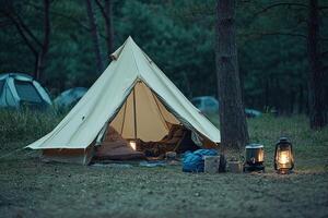 A tent in the woods with a lantern and a lamp photo
