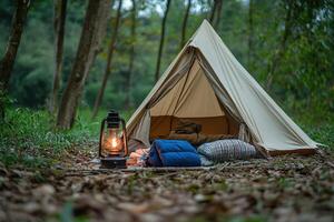 A tent with a lamp and blankets in the woods photo