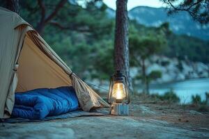 A tent with a light on top of it next to a lake photo