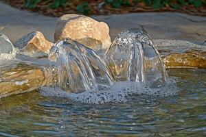 A water fountain with two water jets coming out of it photo