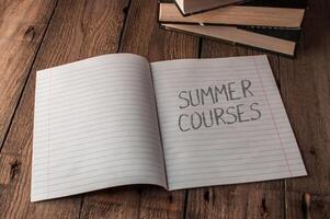A notebook is open to a page with the words Summer Courses written on it photo