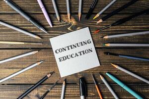 Circle of pencils and pens with the word continuing education written in the center photo