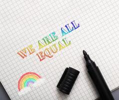 Rainbow is drawn on a piece of paper with the words We are all equal photo