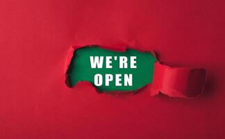 Red background with a green word that says we're open in white photo