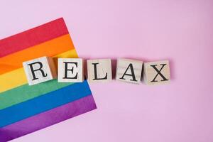 Rainbow flag and a wooden block with the word relax written on it photo