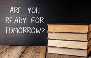 Stack of books with chalk on top that says Are you ready for tomorrow photo