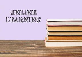 Stack of books with the word online learning written on top photo