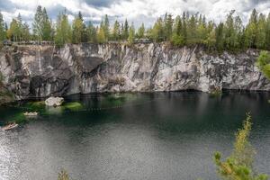 Brightly colored kayaks glide across the emerald waters of Marble Canyon, surrounded by historic stone cliffs and lush greenery photo