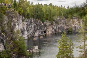 Guests enjoy the natural beauty of Marble Canyon in Karelia, surrounded by lush trees and calm waters while taking in the breathtaking views photo