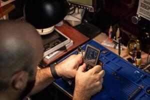 Smartphone battery repair in a workshop with tools and equipment on a cluttered workbench photo