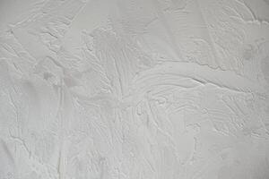 Applying decorative putty. White abstract texture of surface covered with putty photo