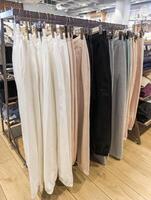 A row of clothes hanging on a rack in a clothing store photo