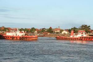 tugboat pulling a heavily laden coal barge sailing on the Musi River. photo
