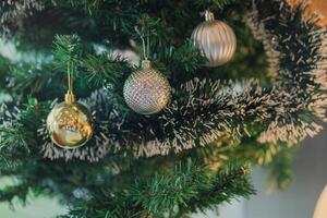 Closed up of disco balls and illuminated garland on green christmas tree, New Year decoration macro photo, Winter holiday light decoration . photo