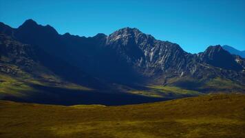 Dramatic mountain range under a clear blue sky during daylight hours video