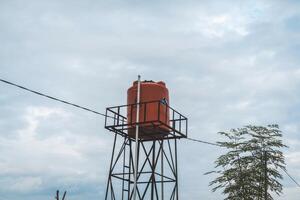 An orange water tower on a hill photo