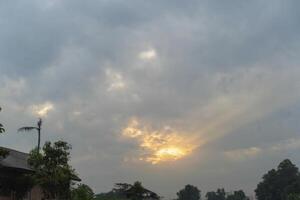 A cloudy sky with a sun shining through photo
