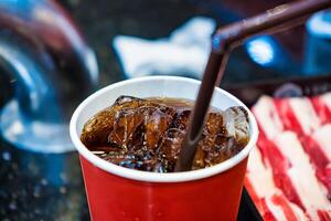 Close-Up of Iced Cola in a Red Paper Cup with a Straw photo