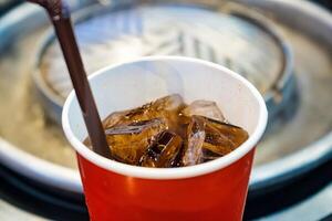 Close-Up of Iced Cola in a Red Paper Cup with a Straw photo