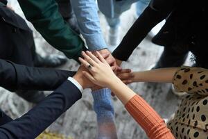 A top view of business people joining hands in a circle, symbolizing unity, collaboration, and shared success in the workplace photo