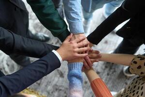 A top view of business people joining hands in a circle, symbolizing unity, collaboration, and shared success in the workplace photo