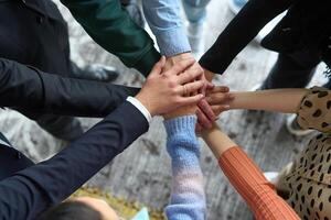 A top view of business people joining hands in a circle, symbolizing unity, collaboration, and shared success in the workplace photo