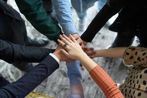 A top view of business people joining hands in a circle, symbolizing unity, collaboration, and shared success in the workplace photo