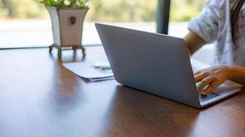 Business woman working from home using laptop online meeting in home office, Closeup image of a woman working and typing on laptop computer keyboard on the table. photo