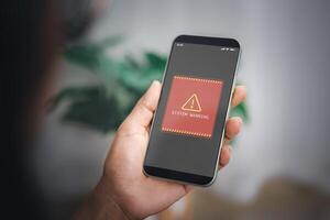 Woman shows smartphone with system hacked alert on screen. Compromised information concept. Internet virus cyber security and cybercrime. Concepts of system maintenance, Access to critical data. photo