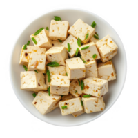 Freshly prepared tofu cubes garnished with green onions in a white bowl. png