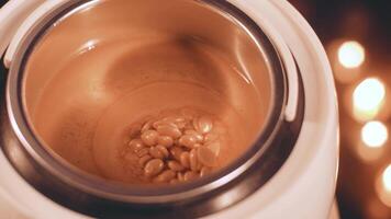 Preparation of gold wax for sugaring. Close-up wax for depilation is heated and melted in a wax melter video