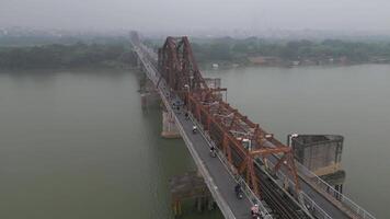 Aerial of traffic on historic Long Bien Bridge and Hanoi city skyline in Vietnam video
